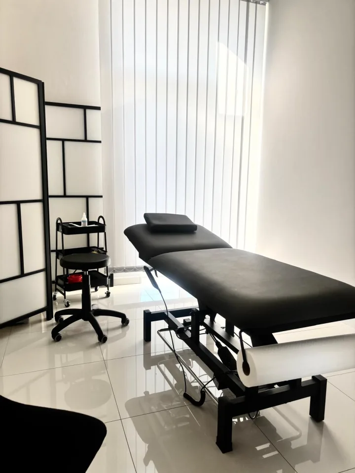 Jasny gabinet terapeutyczny ze stołem zabiegowym i parawanem